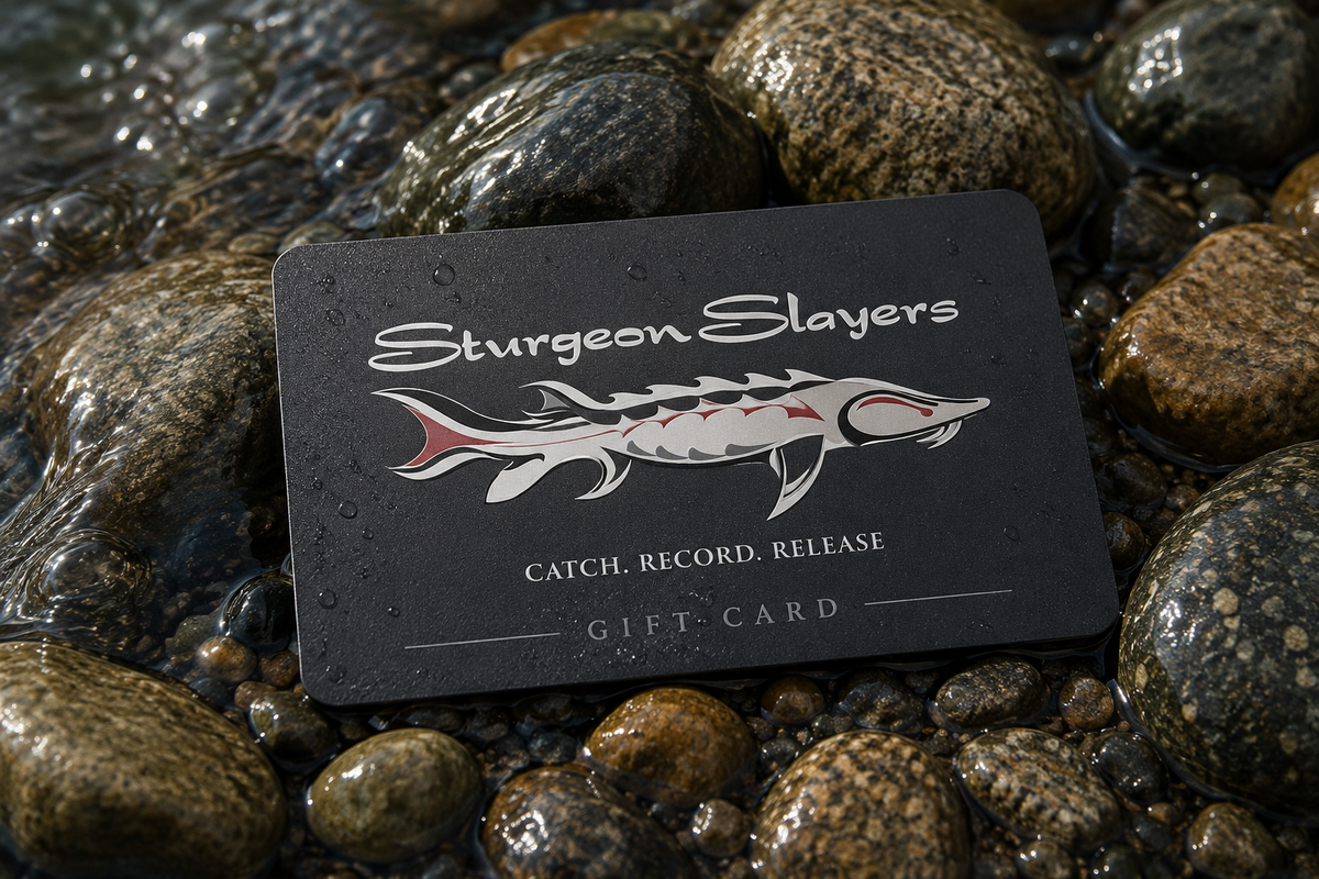 Sturgeon Slayers gift card on wet rocks with water droplets.